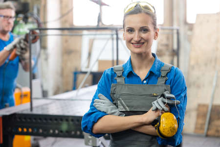 Workers in a metal workshop, man and womanの写真素材