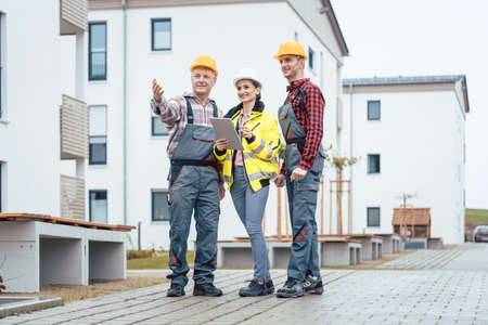 Builder and contractor inspecting new houses and residential buildings on construction siteの写真素材