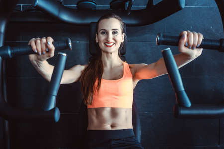 Fit woman exercising in her private gym looking at cameraの写真素材