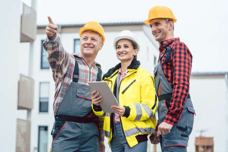 Builder and contractor inspecting new houses and residential buildings on construction siteの写真素材