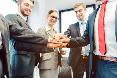 Business Team stacking hands looking at camera traying to lure in new job applicants