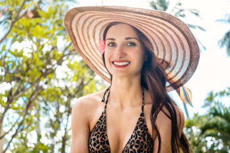 Woman with straw hat at the seaside, smilingの写真素材