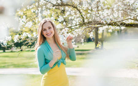 Beautiful woman enjoying the spring blossom in a parkの写真素材