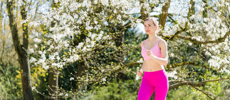 Woman running in spring parkの写真素材