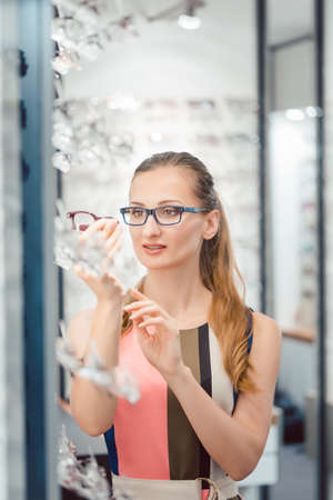 Woman being satisfied with the new eyeglasses she bought in the storeの写真素材