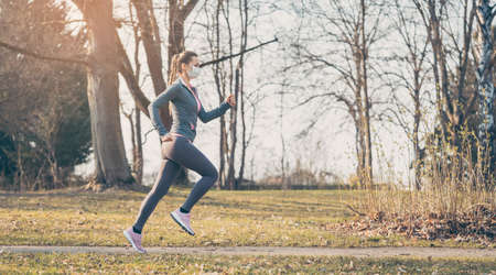 Woman running with face mask to stay healthy during covid-19の写真素材