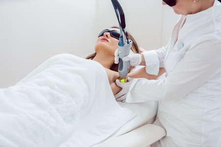 Woman during hair removal using modern laser technologyの写真素材