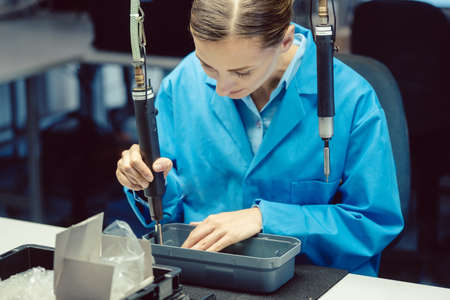 Woman in factory assembling a productの写真素材