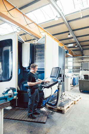 Worker in metal industry operating a modern cnc latheの写真素材