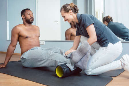 Young man doing fascia training with rollの写真素材