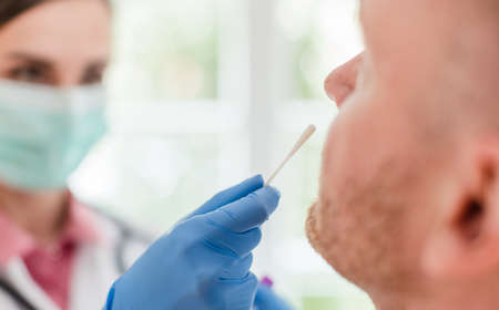Doctor inserting swab in patients nose for  testの写真素材