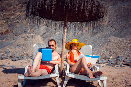 Couple of professionals on the beach working instead of relaxingの写真素材