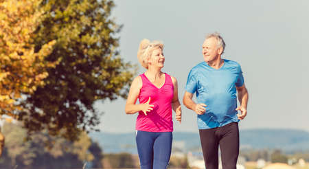 Senior woman and man running doing fitness exercisesの写真素材