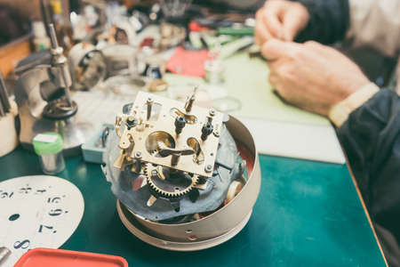 Close up on clockwork of clock to be repaired in watchmaker workshop