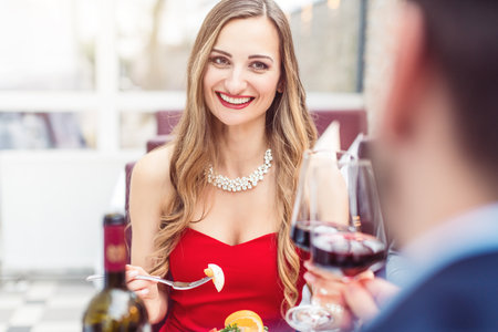 Couple toasting with red wine in romantic restaurantの写真素材