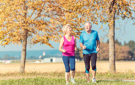 Senior woman and man running doing fitness exercisesの写真素材