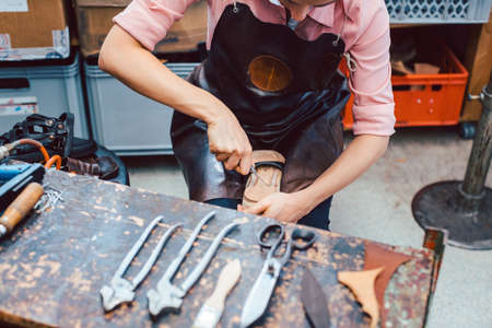 Shoemaker working on the frame of a shoe