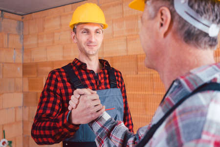 Male construction engineer and builder shaking handsの写真素材