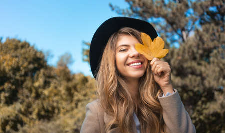 Pretty woman with autumn yellow maple leafの写真素材