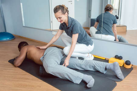 Young man doing fascia training with rollの写真素材