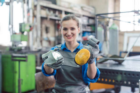 Woman worker in metal factory showing protective workwearの写真素材