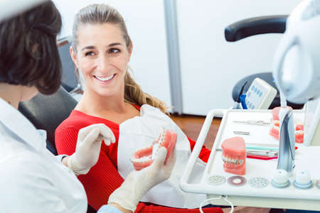 Dentist explaining to patient about denturesの写真素材