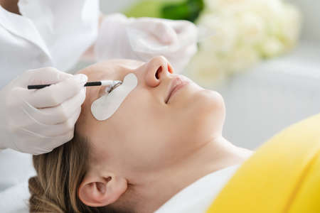 Cosmetician giving eyelash treatment to customerの写真素材