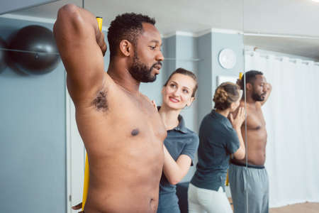 Young man receiving physical therapy on his shoulderの写真素材