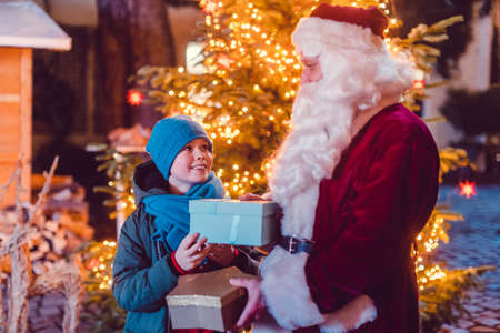 Boy receives a present from Santa Claus himselfの写真素材