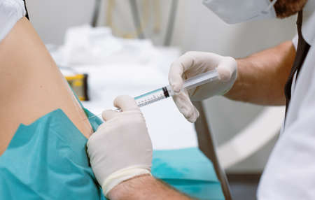 Orthopedic doctor injecting cortisone in slipped disc