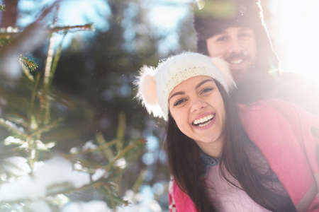 Portrait of young cheerful couple in winter forestsの写真素材