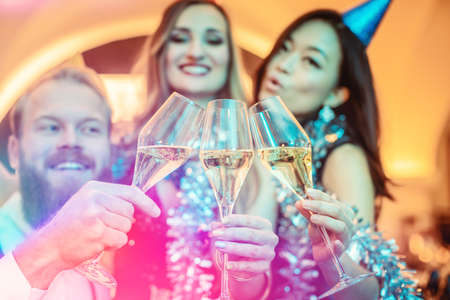 Joyful multiracial friends toasting the flute of champagneの写真素材