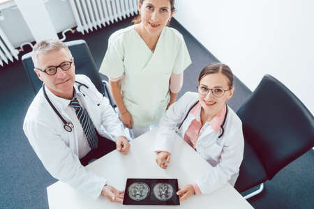 Team of doctors and nurses in meeting using a tablet computerの写真素材