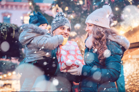 Family with child having fun at the Christmas marketの写真素材