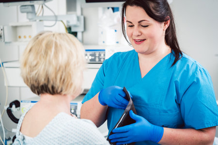 Nurse putting pressure sleeve on patient to measure bloodの写真素材