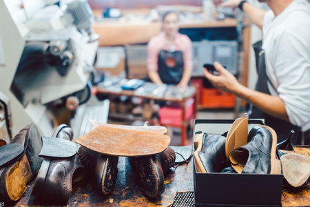 Shoemaker putting glue on sole of a shoeの写真素材