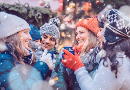 Group of friends drinking mulled wine in the cold on a Christmas Marketの写真素材