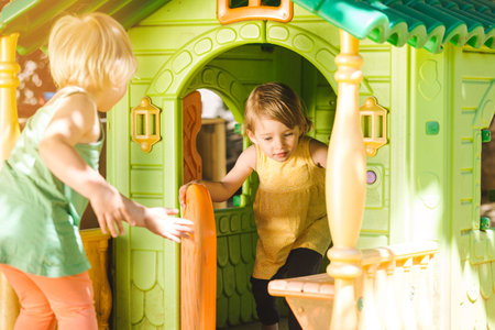 Little girl being absorbed playing in a hutの写真素材
