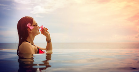 beautiful woman in pool by the sea enjoying a tropical vacation