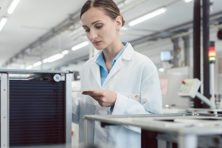 electrical engineer at assembly line inspecting PCB boardsの写真素材