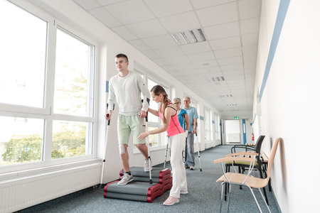 People in rehabilitation learning how to walk with crutchesの写真素材
