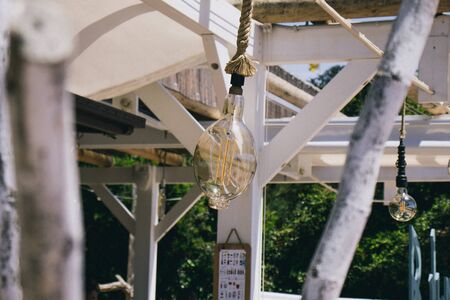 Lamp hanging on a rope at a street cafe on a bright sunny day. New ideas and workplace concept.の写真素材