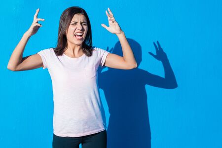 Beautiful cheerful young girl wearing casual clothes standing isolated over blue background on a...