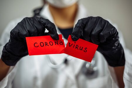 Doctor woman with surgical mask holding a blood test tube positive Coronavirus, isolated on gray background. Female nurse holding nCov2019 sign. Covid-19 and sickness prevention conceptの写真素材