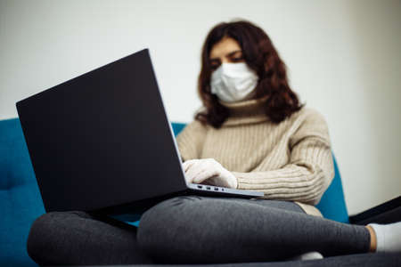 Young woman working from home during quarantine due to coronavirus pandemia. Beautiful girl stays...