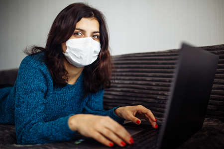 Young businesswoman working from home during quarantine due to coronavirus pandemia. Beautiful girl...