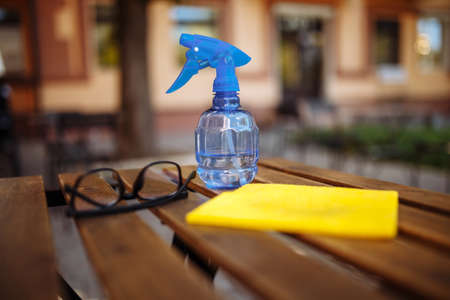 A close-up shot of table disinfectants in a cafe, coffee shop or restaurant with an outdoor terrace. Disinfectants. Spray bottle, rag. New normal concept. preventionの写真素材