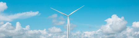 Panoramic photo of a windmill with high wind turbines for generation electricity against the blue...