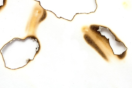 Fire holes in white paperの写真素材