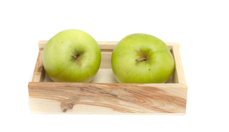 green apples in a wooden crate isolated on whiteの写真素材